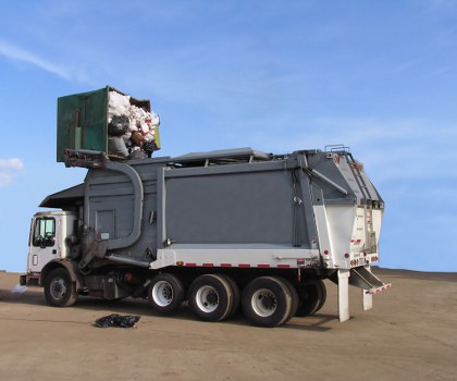 Team members wearing PPE preparing a skip for loading on site
